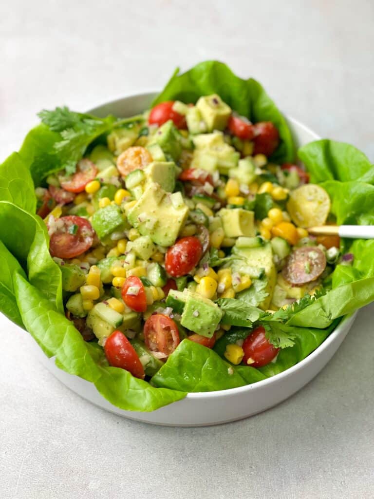 refreshing avocado salad sitting on a bed of butter lettuce