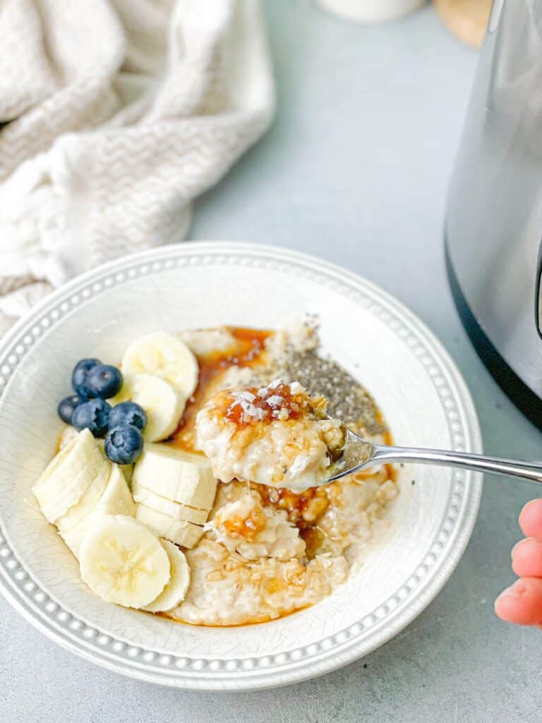 a bowl of delicious steel cut oats with a spoonful scooped out.