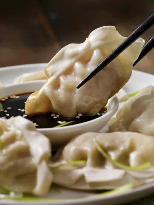 a steamed dumpling dipped into spicy Chinese garlic sauce