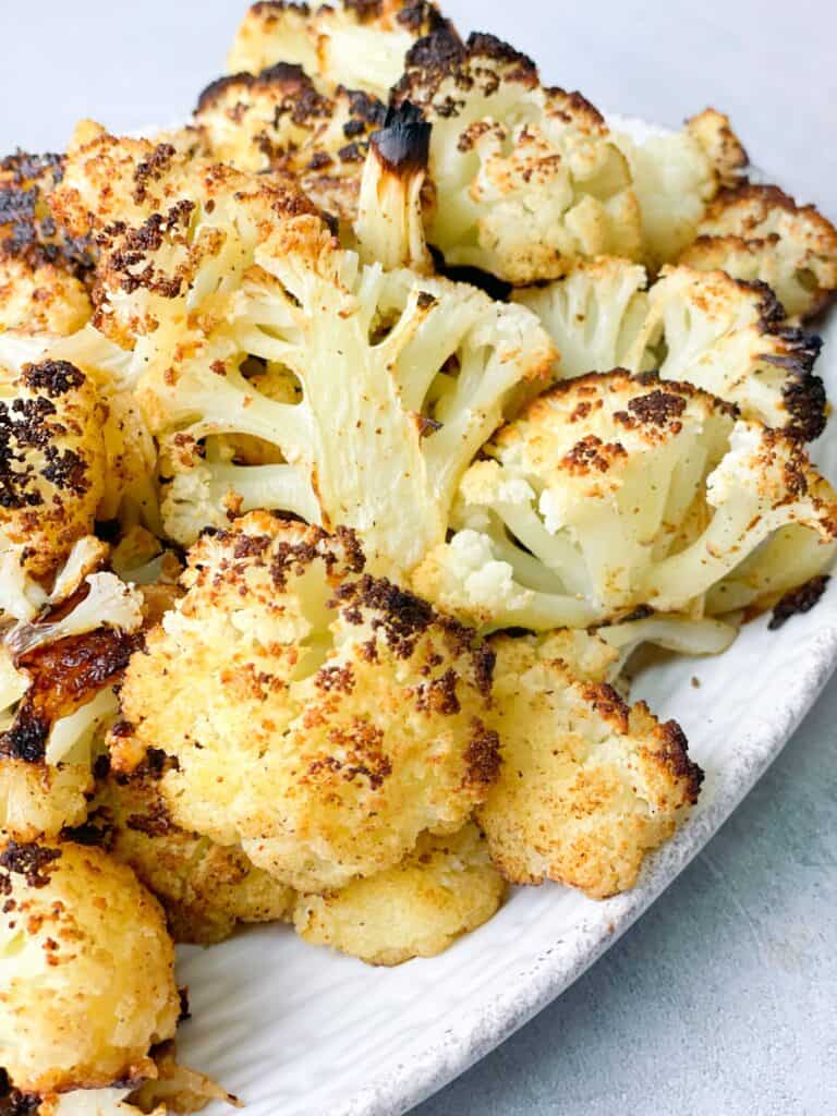 a plate of roasted cauliflower seasoned with olive oil, paprika, garlic, salt, and pepper