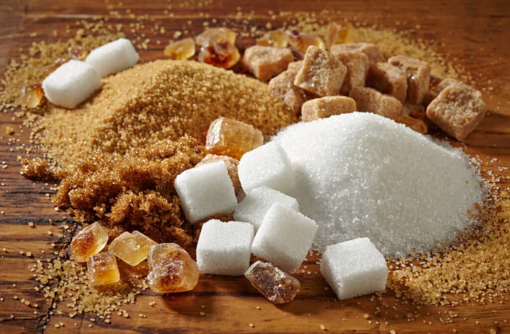 Cubes of white and brown sugar mixed with granulated form of the same kinds of sugar.