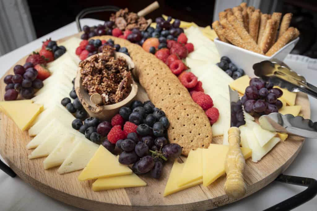 Various cheese, crackers, berries and nuts on a fine charcuterie board