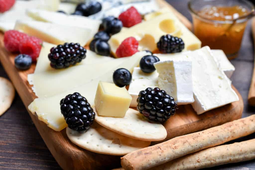 Different types of cheese with berries and jam