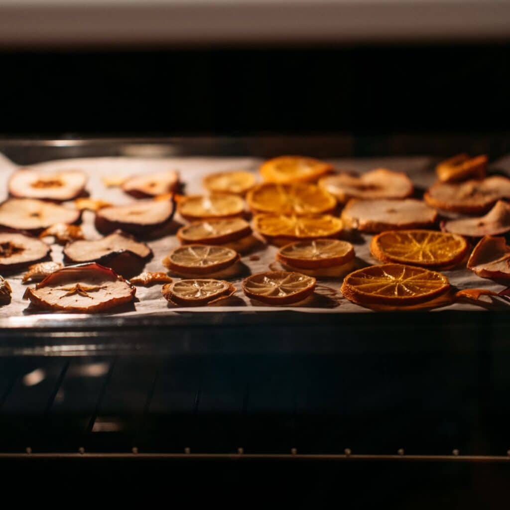 Dried up sliced oranges placed in a tray neatly inside the oven.