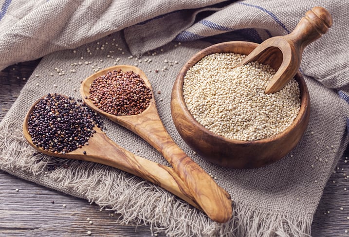 On a piece of cloth, some wooden pots contain quinoa seeds which are said to be better than rice. The seeds are of different types; some are white, others are brown and some others are black quinoas.