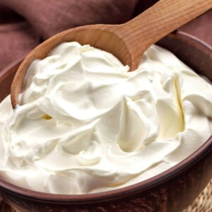a bowl of homemade cream cheese with a wooden spoon