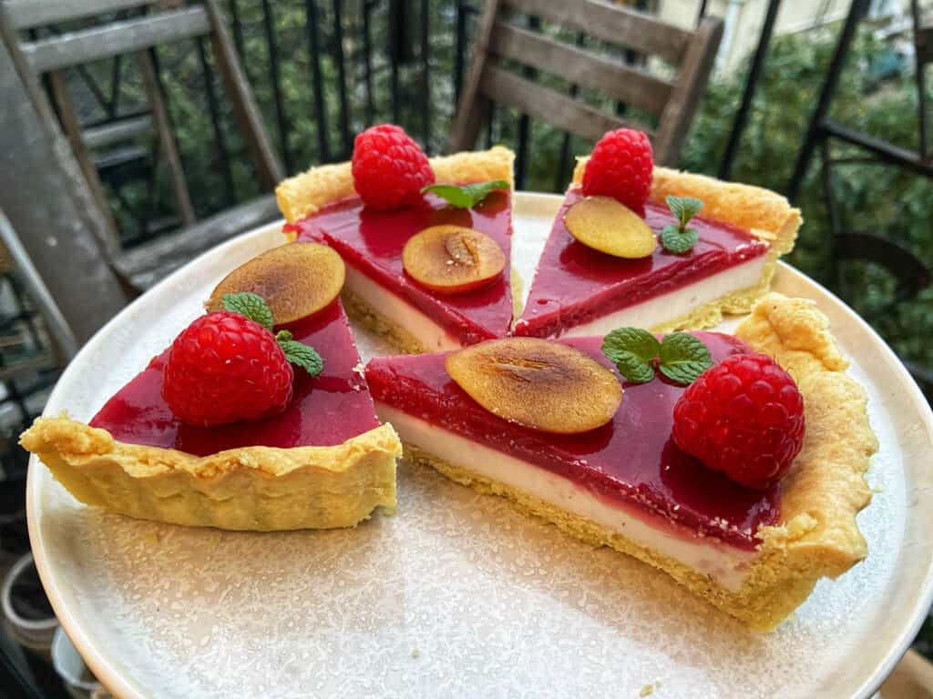 Delicious slices of gluten free tart filled with lemon curd and topped with raspberries jam.