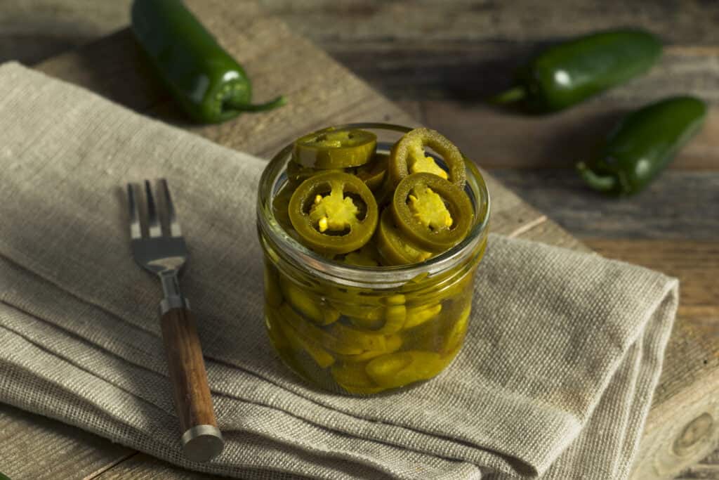 A mason jar filled with pickled jalapeno peppers ready to add to your favorite meal.