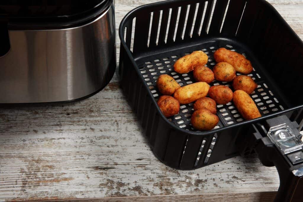 Gold Potatoes are put in an air fryer basket and are ready  to be served.
