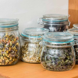 glass jar that contains dried herbs