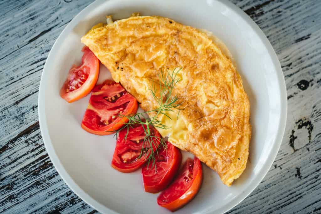 omelette with cheese and fresh tomatoes garnish