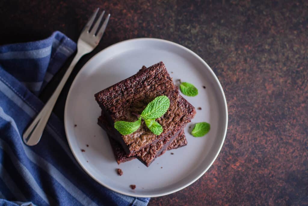 Homemade chocolate brownies on dark stone background