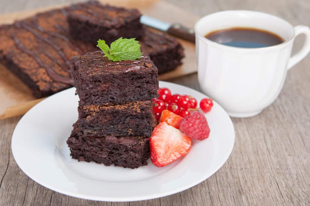 Healthy gluten free brownies stacked above each other and served with fresh berries