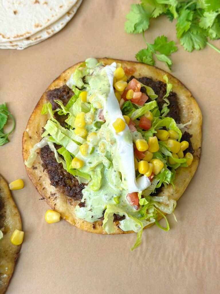 When you bite into this viral smashed taco, your mouth will experience nothing less than a delectable explosion of delight, from the tender ground beef to the sauces topped with.