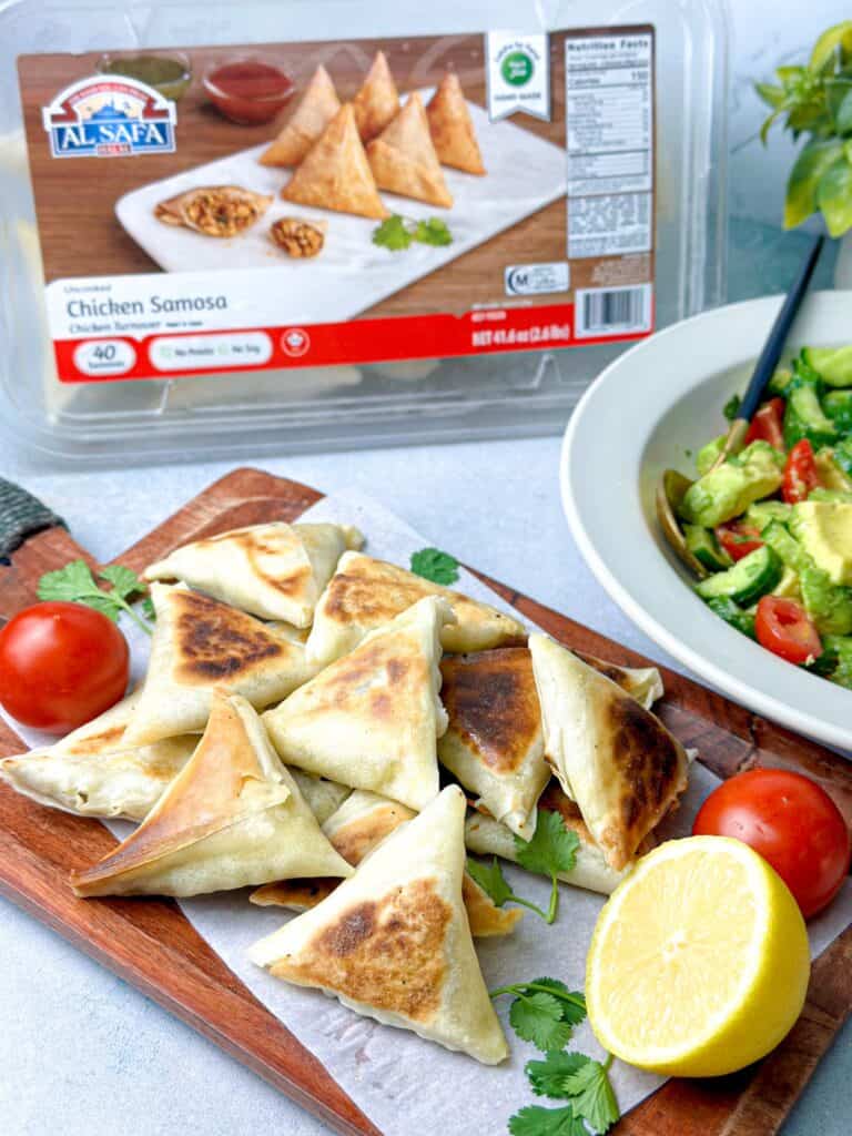 Delicious baked chicken samosas paired with a plate of cucumber avocado salad.