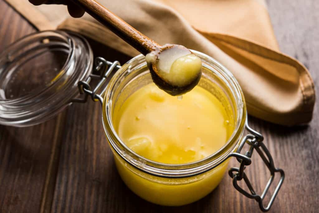 a glass container filled with ghee (clarified butter) used for cooking