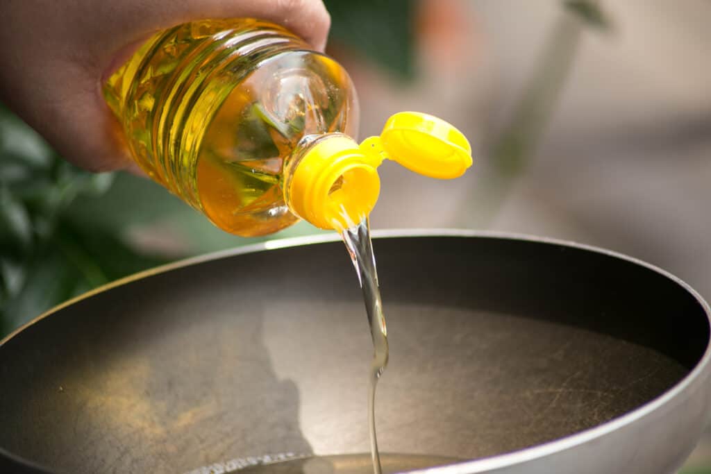 Streaming oil into a pan for deep frying.