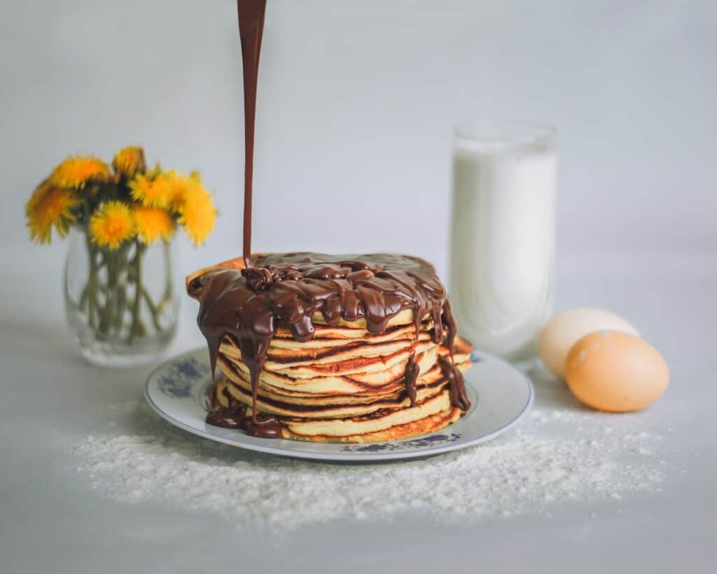 A drizzle of high protein chocolate sauce on top of pancakes 