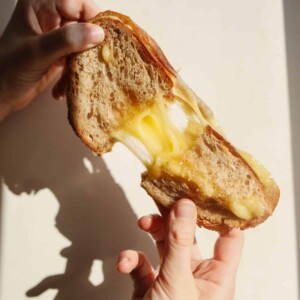 A delicious looking grilled cheese sandwich with an amazing cheese pull.