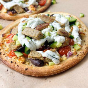 baked gyro Mediterranean pizza filled with cucumber, cherry tomatoes, feta cheese, gyro meat, and tzatziki sauce