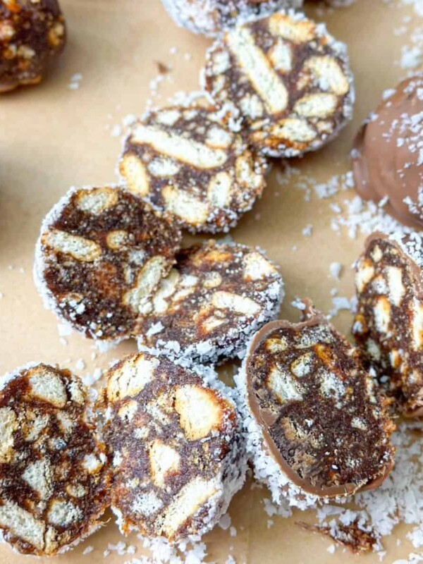 Date Balls drenched in chocolate, sprinkled with coconut, and cut in half.
