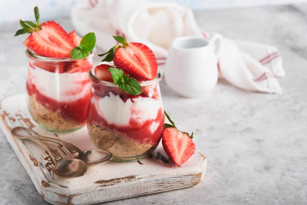 Pudding parfaits with strawberries in a glass on an old gray concrete table background Cheesecake without baking. The best part is that this cheesecake doesn't require any baking, making it an easy and hassle-free dessert option for any occasion. 