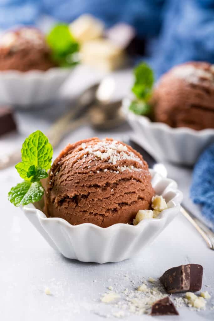 A scoop of Nutella ice cream in a bowl with mint leaves.