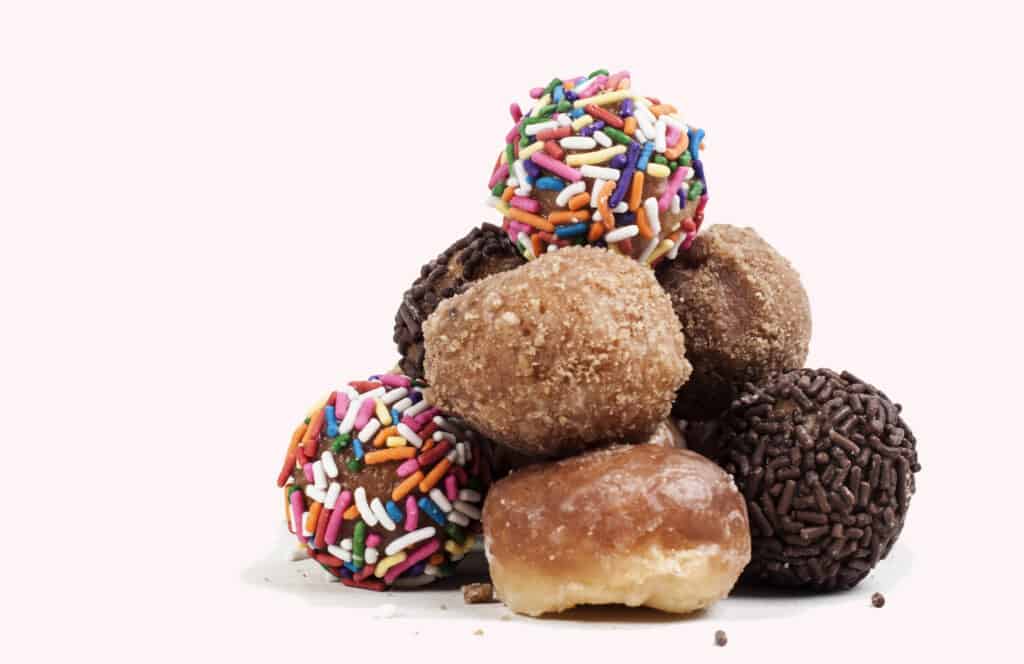 Variety of colorful Donut holes stacked up.