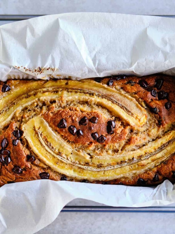 gluten-free chocolate oat banana bread topped with chocolate chips and halved bananas