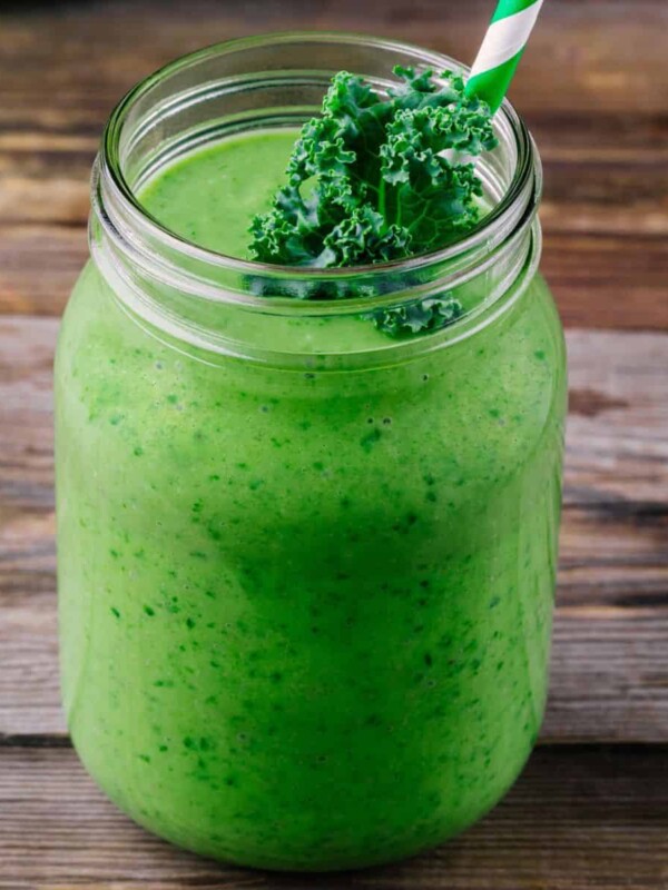 detox green smoothie with kale in a mason jar on wooden background