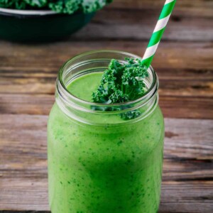 Healthy detox green smoothie with kale in mason jar on rustic wooden background