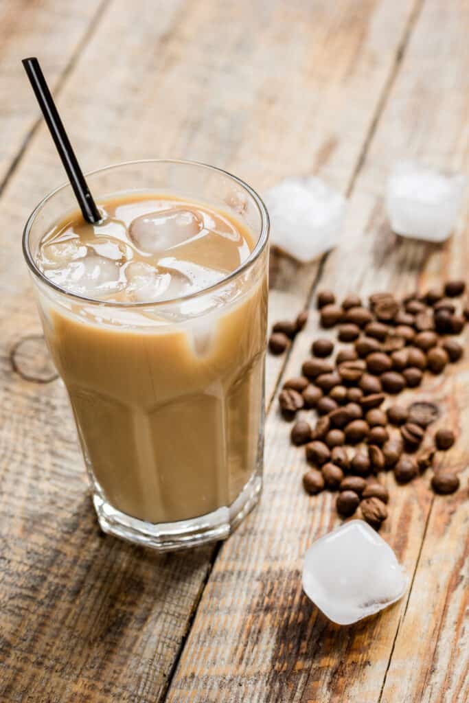 cold coffee glass with ice cubes for cafe menu on wooden table background
