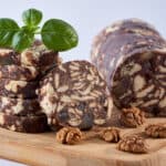 no bake lazy cake slices on a wooden cutter alongside some walnuts.