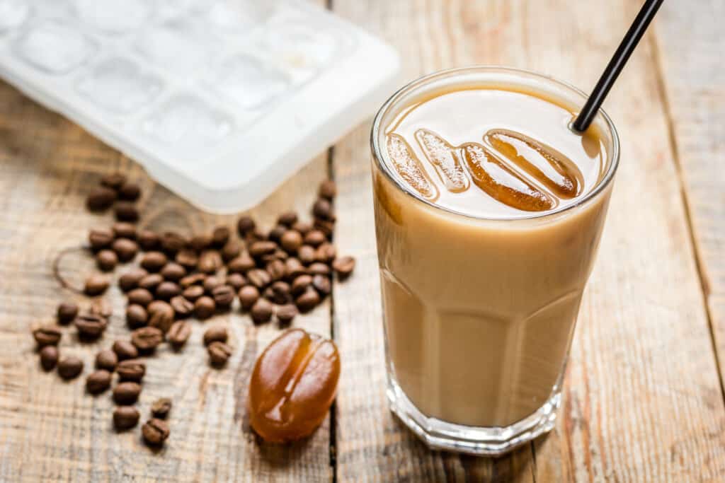 iced coffee with beans for cold summer drink on wooden table background