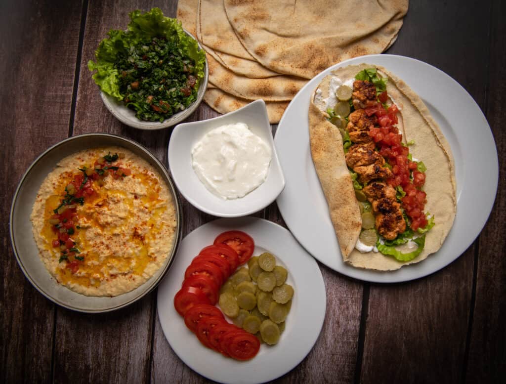 Lebanese recipe of chich taouk, garlic cream, toum, in a Lebanese bread, tabbouleh and chickpea puree, hummus High quality photo