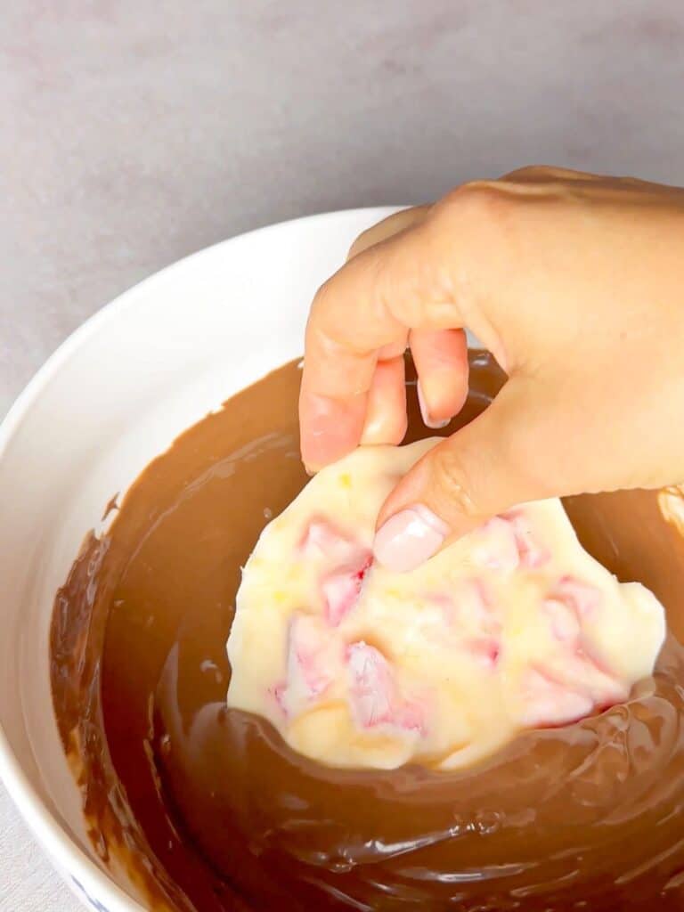 A frozen yogurt and fruit bars is coated with the chocolate mix.