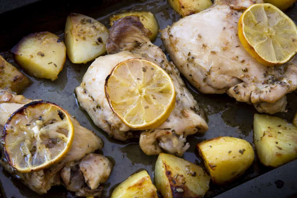 a pan of oven-baked chicken thighs marinated in lemon and herbs to get the ultimate tender chicken meat