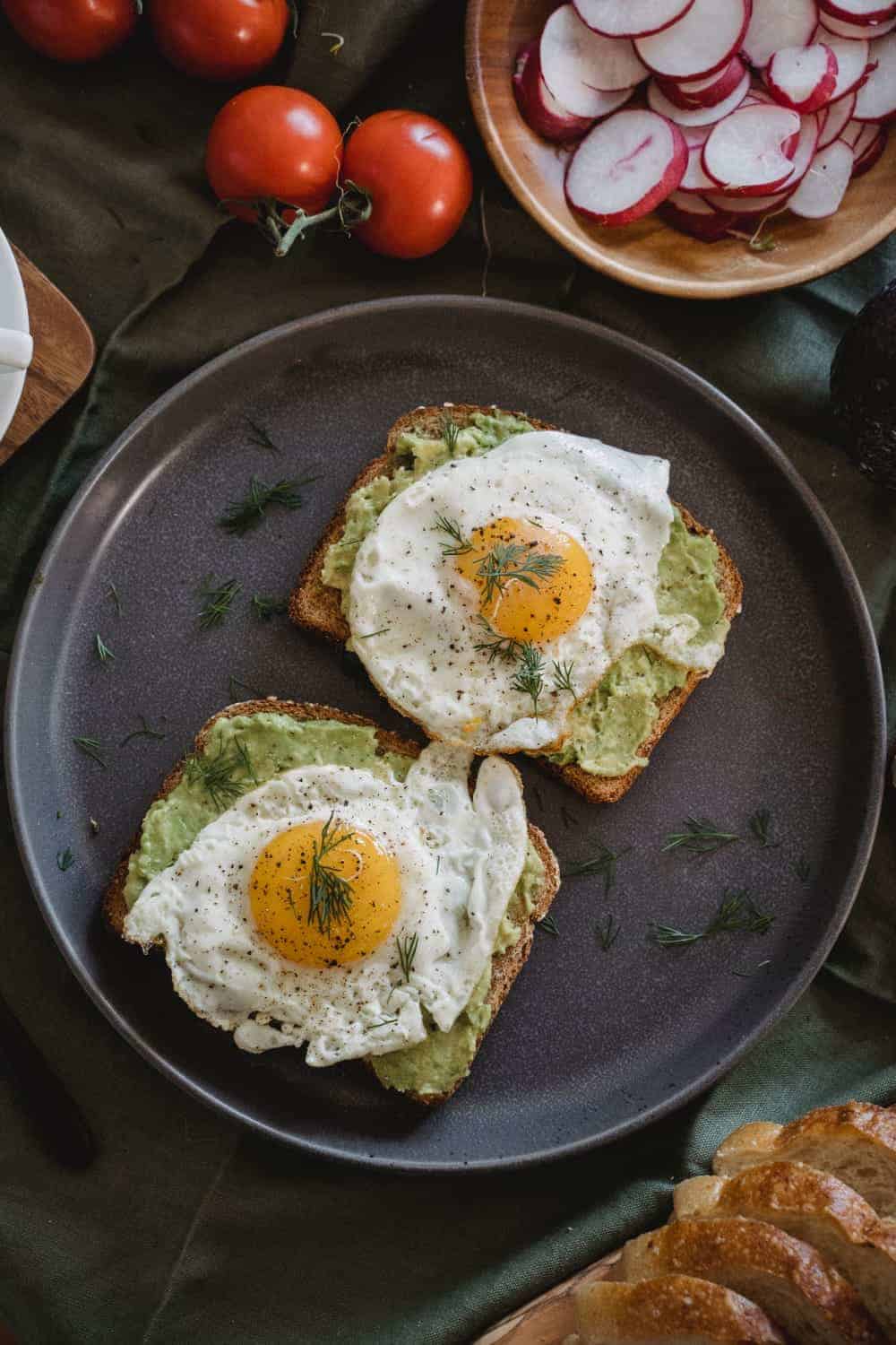 This amazing Pesto eggs plate is made with four main ingredients: pesto, eggs, bread, and seasoning, and topped with some basil leaves and chili flakes.