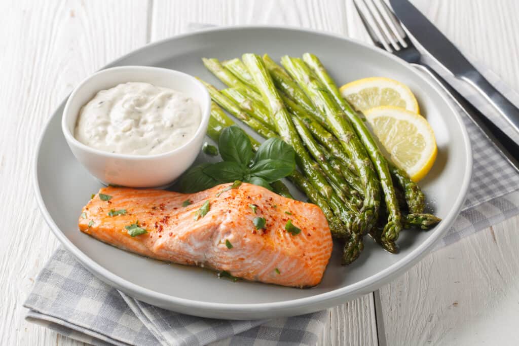 Delicious baked salmon with crispy asparagus served with tgarlic sauce