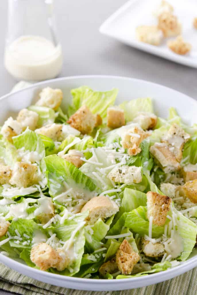 a fresh caesar salad, with romaine lettuce hearts, croutons, parmesan cheese and dressing. 