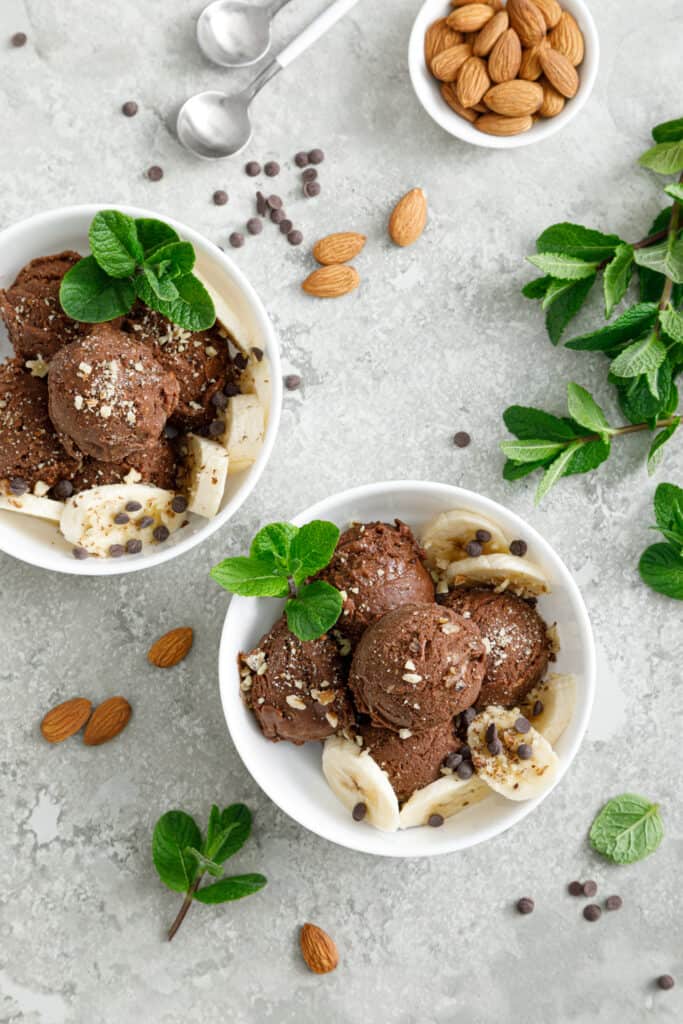 a top view of chocolate and banana fruit ice cream with almond nuts served in two bowls