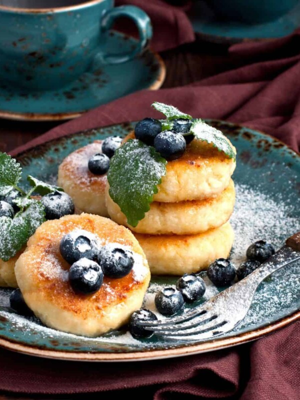 colorful pancakes featuring cottage cheese, fresh blueberries, and a sprinkle of powdered sugar on top