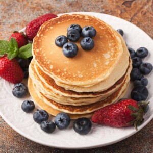 delicious golden pancakes served with fresh blueberries and strawberries