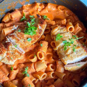rigatoni pasta with pink sauce topped with chicken breasts