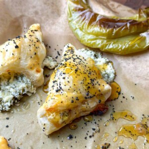 a close up view of puff pastry triangles filled with feta cheese and new mexico peppers drizzled with honey