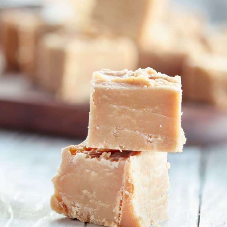 Two squares of peanut butter fudge are stacked on top of each other.