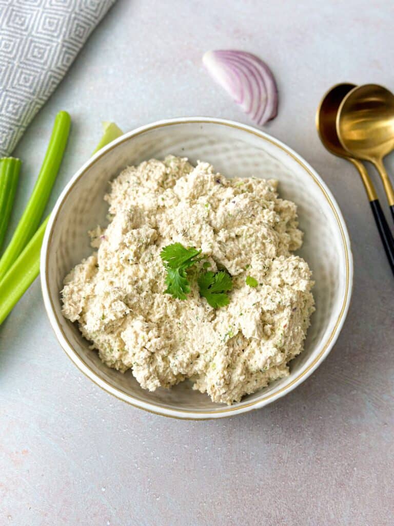 a bowl of tuna and pesto filling garnished with fresh cilantro leaves