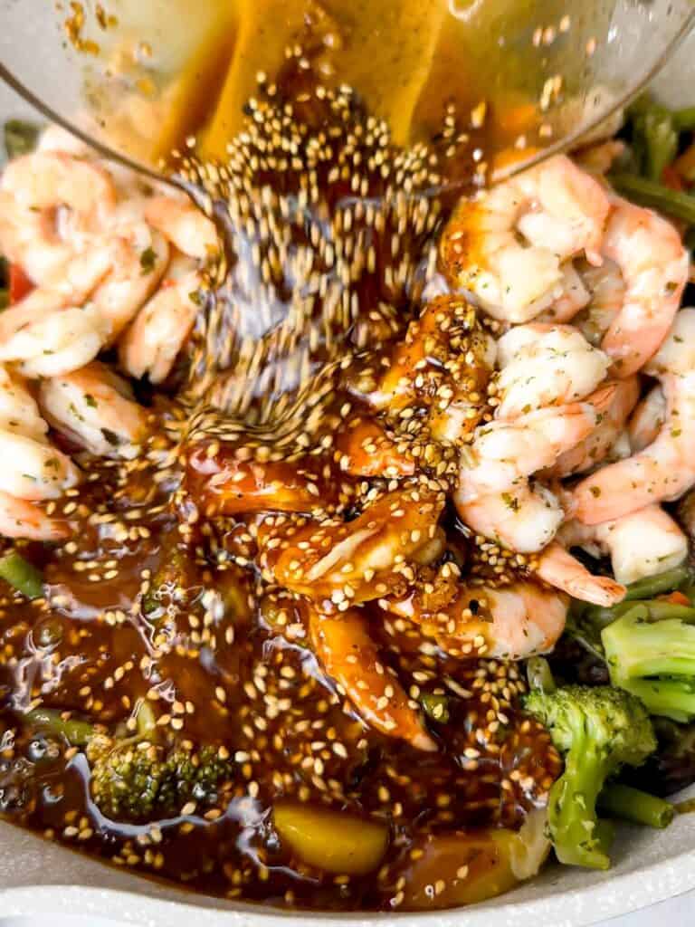 honey soy sauce with sesame seeds drizzled on shrimp stir-fry