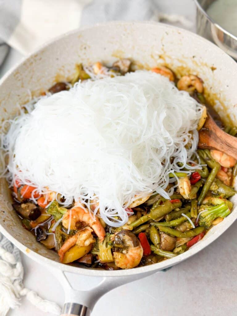 vermicelli noodles on top of stir fry shrimp