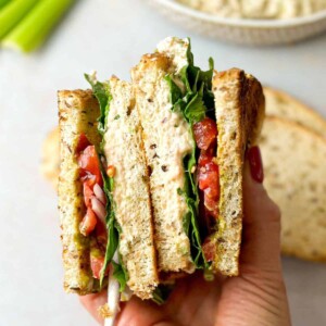 viral tunacado sandwich split into two pieces with fresh veggies and tuna-pesto combination